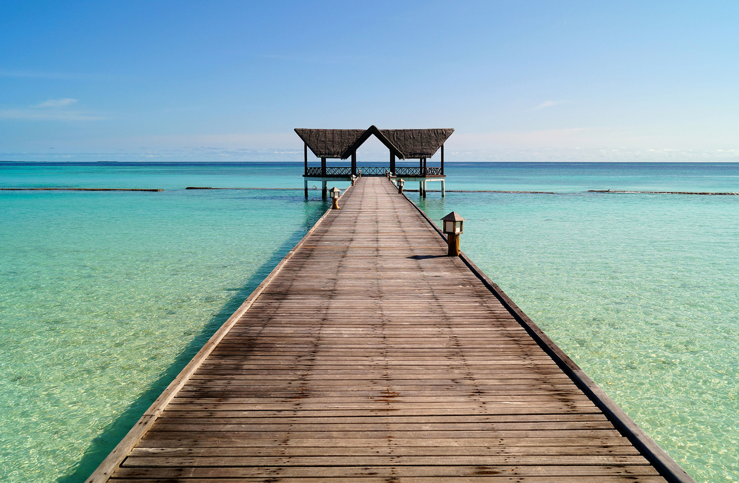 Wooden dock extending into a calm, crystal-clear lake